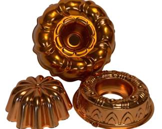 40 - 3 Copper Cake Molds (Description): A collection of three copper cake molds featuring assorted decorative designs. The lot includes molds in various shapes suitable for bundt cakes and ring-shaped desserts, each with distinctive fluted and ornamental patterns. The polished copper finish provides both functional bake ware and attractive kitchen display pieces.