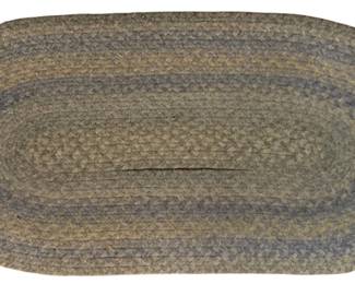 109 - Oval Braided Hook Rug 43"x22.5" (Description): Oval braided hook rug in muted earth tones featuring concentric oval bands in shades of sage green, tan, and dusty blue-gray. The traditional braided construction creates a classic country aesthetic. Measures 43 inches by 22.5 inches.