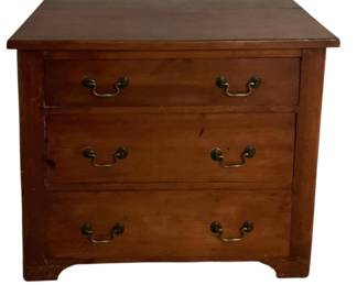 455 - 3-Drawer Small Chest 26"x29"x17.25" (Description): A three-drawer chest crafted in warm-toned wood with a rich finish. The piece features three spacious drawers, each fitted with brass bail pull handles on round back plates. The chest rests on bracket feet and has a simple, classic silhouette. Measures 26 inches high by 29 inches wide by 17.25 inches deep.