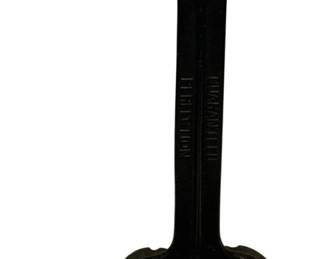 101 - Cast Iron Shoe Cobbler Stand 15" (Description): Cast iron shoe cobbler stand with black painted finish. Features a T-shaped top platform for shoe repair work, a central shaft marked "GUARANTEED PERFECTION," and a decorative shoe-shaped base. Measures 15 inches in height. Shows wear consistent with age and use.