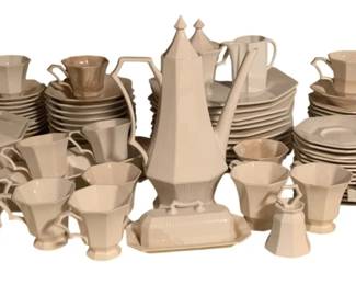 51 - 81pc Nikko Classic Collection China Set (Description): An 81-piece Nikko Classic Collection china set featuring an elegant Art Deco-inspired design. The set includes a tall covered coffee pot with distinctive pointed finial, covered serving dishes, cups and saucers, dinner plates, salad plates, a covered butter dish, and additional serving pieces. The collection is primarily in white with some pieces accented in a soft peach or coral tone. The angular, geometric shapes and