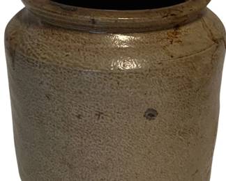 89 - Stoneware Crock 4.25"x4.5" (Description): Antique stoneware crock featuring a salt-glazed finish with characteristic brown Albany slip interior rim. The cylindrical vessel has a rolled lip and shows the textured surface typical of traditional American stoneware pottery. Measures 4 1/4 inches by 4.5 inches.