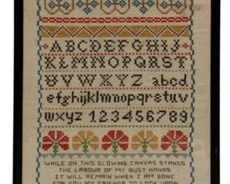 65 - Framed Needlepoint Sampler w/ Alphabet (Description): Framed needlepoint sampler featuring decorative bands of floral and geometric motifs, complete uppercase and lowercase alphabets, and numerals 1-9. The piece includes a verse reading "While on this glowing canvas stands the labor of my busy hands it will remain when I am gone for you my friends to look upon" and is initialed "WWG" in the lower right corner. Worked in muted tones of red, blue, green, gold, and