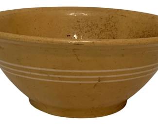 203 - Antique Yellow Ware Mixing Bowl 4.5"x10.5" (Description): Antique yellow ware stoneware mixing bowl featuring a classic banded design with white slip stripes around the exterior. The bowl has a rolled rim and footed base typical of 19th century American kitchenware. Shows expected wear consistent with age and use. Measures 4.5 inches tall by 10.5 inches in diameter.