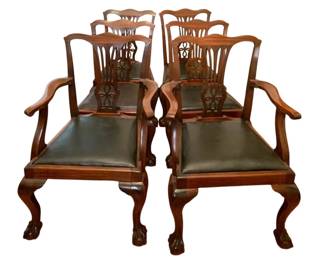 98 - 10 Chippendale Style Dining Chairs (Description): Set of ten Chippendale style dining chairs featuring rich mahogany wood construction with pierced splat backs displaying elegant ribbon and scroll motifs. The set includes two armchairs and eight side chairs, each with dark green leather upholstered slip seats. The chairs rest on gracefully curved cabriole legs terminating in classic ball and claw feet. Measures 39 inches high by 23 inches wide by 26 inches deep.