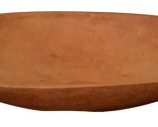 511 - Antique Dough Bowl 5.5"x24.5"x13" (Description): Antique wooden dough bowl with a warm, natural patina consistent with age and use. This hand-turned oval bowl features gently sloping sides and a smooth, well-worn interior surface. The bowl measures 5.5 inches high by 24.5 inches long by 13 incheswide, making it a substantial piece suitable for display or practical use.