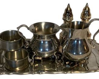 38 - Lot Pewter & Silver plated Tableware w/ Tray (Description): A collection of pewter and silver plated items including creamers, salt and pepper shakers with decorative finials, napkin rings, and a scalloped-edge serving tray.