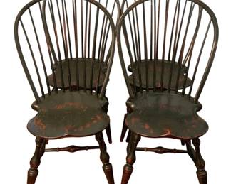 96 - 4 Windsor Style Spindle Back Chairs (Description): Set of four Windsor style spindle back chairs featuring classic bow back design with multiple spindles. The chairs display a dark finish with attractive distressed patina revealing warm undertones beneath. Each chair has a shaped saddle seat and turned splayed legs connected by turned stretchers. Measurements: 38" x 18" x 17".