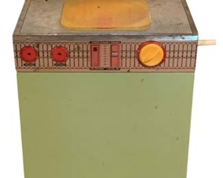 427 - Wolverine Toy Washer 28"x18"x15" (Description): Wolverine toy washer measuring 28 inches by 18 inches by 15 inches. This vintage tin lithograph toy washing machine features a cheerful color scheme with a yellow top back splash decorated with printed detergent bottles and dial graphics. The front panel displays lithographed control knobs in red and yellow against a decorative brown scrollwork pattern. The body is finished in a pale green enamel. A hinged yellow plastic