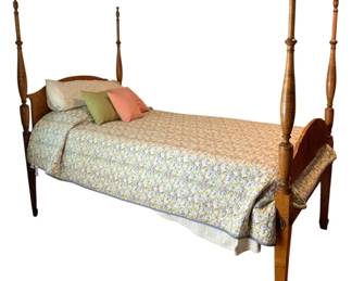 401 - Twin Size Four Poster Bed w/ Bedding (Description): Twin size four poster bed with bedding included. This handsome bed features turned wooden posts with decorative finials, a shaped headboard and footboard, and tapered legs. The warm wood finish exhibits traditional American styling. Includes coordinating bedding with quilted coverlet and accent pillows. Measures 66.5" x 79" x 44".