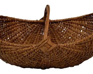 201 - Antique Woven Splint Gathering Basket (Description): Antique woven splint gathering basket featuring a traditional buttocks-style construction with a bent wood handle. The basket displays a classic diamond pattern at the base where the ribs intersect. Measures 14 inches by 25 inches by 16 inches.