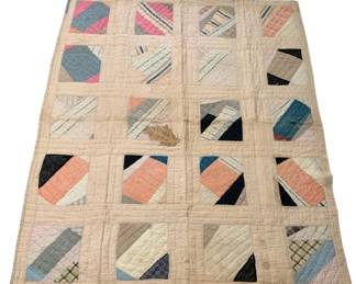 525 - Vtg Handmade Patchwork Quilt 71"x50" (Description): Vintage handmade patchwork quilt featuring a geometric block pattern with diagonal design elements. The quilt displays an array of fabrics including plaids, stripes, and solid colors in shades of pink, blue, navy, cream, and tan set against a neutral muslin background. Hand-quilted with visible stitching throughout. Shows signs of age and use with some staining and wear consistent with a well-loved antique textile. Measures