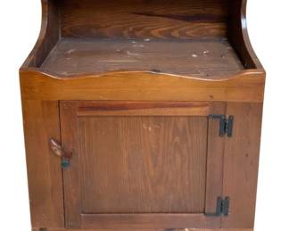 306 - Vtg Pine Washstand w/ Cabinet 36"x28"x17" (Description): Vintage pine washstand featuring a single cabinet door with iron strap hinges and a turned wooden latch. The piece has an open upper shelf area with curved side supports and a flat top surface. The warm honey-toned pine shows natural wood grain throughout. Measures 36 inches tall by 28 inches wide by 17 inches deep.