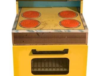 428 - Sears Toy Stove 38"x18"x15" (Description): Sears toy stove in yellow and turquoise lithographed tin. This vintage child's kitchen appliance features a stove top with four printed orange burners, a front-opening oven door with viewing window, and a detailed control panel with printed clock and knobs. The piece displays charming mid-century design elements typical of 1960s-era play kitchen toys. Measures 38" x 18" x 15".