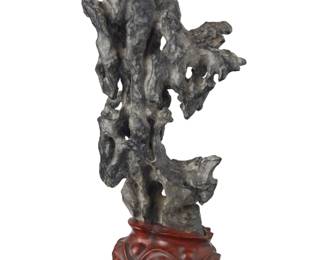 1299 A Chinese Ling Bi scholar stone 20th century Mounted on a carved hardwood stand Stone: 13.75" H x 7.5" W x 4" D; Overall: 16.75" H Estimate: $800 - $1,200