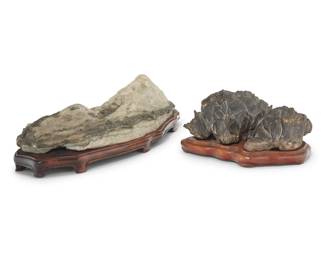 1300 Two Chinese style scholar stones 20th century Each on a custom fitted wood base 2 pieces Larger overall: 4.75" H x 17.5" W x 8.5" D; Smaller overall: 4.25" H x 8.75" W x 7.125" D Estimate: $200 - $300