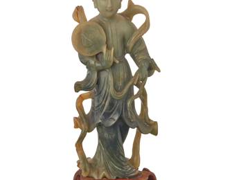 1302 A Chinese jade carving of a beauty 20th century Raised on a carved hardwood stand Figure: 7.75" H x 3.125" W x 1.5" D; Overall: 8.625" H Estimate: $500 - $700