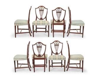 1155 A set of eight George III style mahogany side chairs Early 20th century Each with shield-back and seat upholstered in a floral pattern fabric with passementerie trim 8 pieces Each: 37.75" H x 22" W x 21" D Estimate: $400 - $600