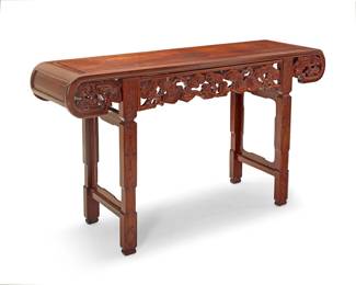 1315 A Chinese carved hardwood altar table 20th century With rolled ends above pierced cloud motifs, raised on pedestal supports carved with taotie masks 33.5" H x 57.5" W x 16.25" D Estimate: $500 - $800