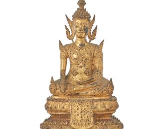 1334 A Burmo Thai gilt metal Buddha figure Rattanakosin Period (1782-1932) With inset glass accents, depicted with hands in bhumisparsha mudra, seated on a tiered base 11.75" H x 7.375" W x 5" D Estimate: $300 - $500