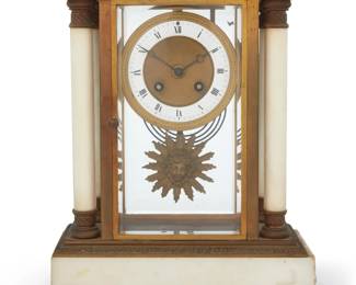 1127 An Empire style marble mantel clock Early 20th century Impressed to movement: MEDAILLE D'OR / Samuel Martí / Paris 1900 With twin-train movement striking on a gong, an enameled metal and parcel-gilt dial bearing Roman numeral hour markers, and a sun mask pendulum, housed in a glazed brass and marble architectural case with columnar accents at corners 13.125" H x 10.625" W x 5.375" D Estimate: $500 - $700