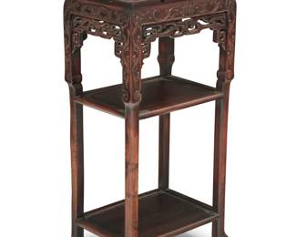 1319 A Chinese carved hardwood table Mid-20th century With inset marble top above a carved and openwork apron and two undertiers, raised on ball and claw feet 34" H x 16.5" W x 12" D Estimate: $300 - $500