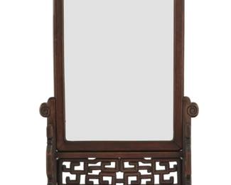 1294 A Chinese carved hardwood table mirror Early/mid-20th century The mirror slides into the stand, with meandering openwork Overall: 29.75" H x 18.5" W x 9" D Estimate: $200 - $400