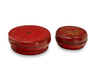 1257 Two Chinese red lacquered wood storage containers 20th century Comprising one with a metal ring handle and another decorated with carved and gilt-accented figures 2 pieces Figures: 8" H x 10" Dia.; Handle: 8.5" H x 24" Dia. Estimate: $300 - $600