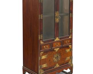 1313 A Chinese style wood display case 20th century With brass hardware and glazed cabinet doors revealing a single shelf above three drawers and a lower cabinet 49.75" H x 27" W x 15.5" D Estimate: $500 - $700