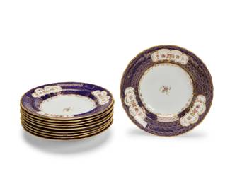 1015 A set of ten Staffordshire porcelain soup plates Early 20th century Each with red printed factory marks and stamped: Ye olde Hall Potterie / Staffordshire England / 1790; further marked with red painted pattern: 7503; one with retailer's mark for Richard Briggs, Boston; three with faint retailer's mark for Gilman Collamore & Co. Fifth Avenue & 30th, New York Each with cobalt blue rims with gilt circular pattern decoration and polychrome flowers on white ground 10 pieces Each: 9.5" Dia. Estimate: $100 - $200