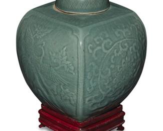 1268 A Chinese celadon porcelain ginger jar Late Qing Dynasty (1644-1912) or later Decorated with two phoenix figures and scrolled motifs in low relief, raised on a hardwood stand Jar: 9.125" H x 7.75" W x 7.75" D; Stand: 1.875" H x 4.75" W x 4.75" D Estimate: $300 - $400