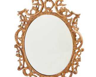1101 A George III style giltwood wall mirror Late 19th/early 20th century The oval plate within acanthus, C-scroll, and floral spray surround 52" H x 33" W x 6" D Estimate: $400 - $600