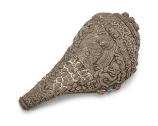 1301 A Tibetan Buddhist sterling silver clad conch shell 19th/20th century XRF tested for sterling Set with turquoise and coral accents, depicting a central Buddha figure with dragons, animals, and mythical beasts 10.25" H x 5.25" W x 4.5" D Estimate: $300 - $500