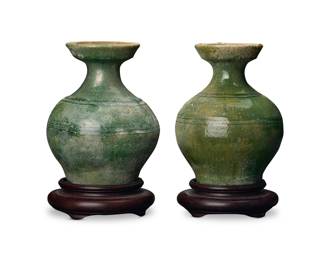 1270 Two Chinese green glazed pottery pear form vases Han Dynasty (206 BCE-220 CE) or style Each raised on a carved hardwood stand 2 pieces Each: 6.25" H x 4.875" Dia. approximately; Each stand: 1.5" H x 4.75" Dia. Estimate: $300 - $500