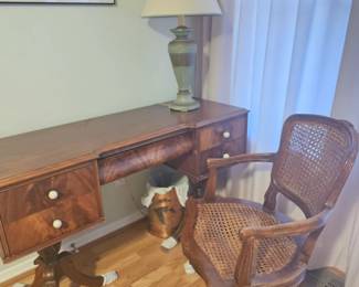 antique bowed secretary and chair, feet are covered for protection