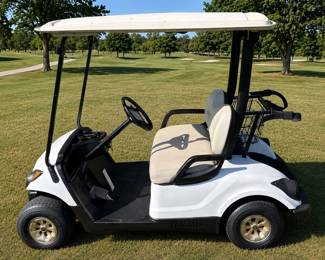A white Yamaha G29 "Drive" golf cart with a rear seat kit.