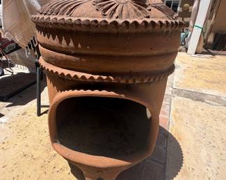Mexican-style clay chiminea features a terracotta finish