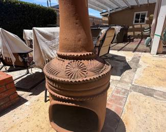 Mexican-style clay chiminea features a terracotta finish