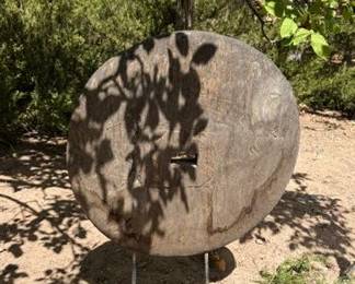 Large antique wooden Indian cart wheel on metal stand