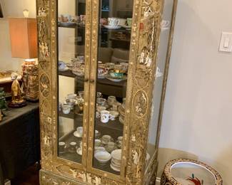 Chinese Chinoiserie styl armoire featuring intricate gold leaf and raised lacquer scenes of traditional scenes and landscapes