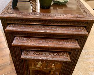 Set of four Chinese nesting tables.  A very ornate high relief carvings which include ivory colored stones and hand painted images