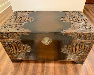 Chinese wedding chest.  Intricately carved teak with brass latch.  It features an oceanscape with carved high relief boats.  It is carved, painted, and includes small stones with a cedar lining