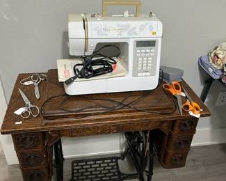 Portable sewing machine sitting on vintage cabinet
