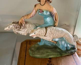This vintage mid-century chalkware sculpture captures an elegant woman strolling with her graceful Borzoi dogs in true Art Deco style. It’s the kind of piece that instantly sparks conversation and brings a touch of old-world charm to any collection.