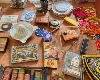 This unique assortment includes historical patches, tiny figurines, and classic home items. It is a dream collection for vintage lovers and flea market hunters looking for rare finds.