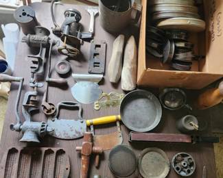 Looking at all these pieces and wondering about the hands that used them. From the 1945 16mm film reels to the old kitchen tools, every object on this table has a story to tell. Which one catches your eye first?