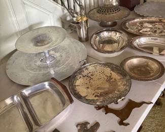 A beautiful assortment of vintage and antique metalware, including sterling silver, silver-plated items, brass, and aluminum serving pieces.