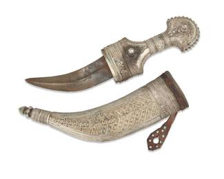 2032 An Arabian silver jambia knife 19th century With script etched into the pommel; XRF tested for .800 silver Curved steel blade, the sheath with leather strapping Blade: 6.375" L; Hilt: 7.5" H x 3.25" W x 2.25" D; Overall: 19" L x 6.5" W x 2.25" D Estimate: $500 - $700