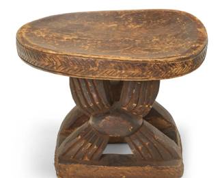 2030 An African carved hardwood stool 20th century, likely Bamum; Cameroon The oval top on stylized X-form supports 16.25" H x 21.5" W x 18.75" D Estimate: $200 - $400