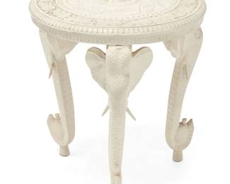 2026 An Anglo-Indian style white painted occasional table 20th century The white painted carved wood table raised on three elephant-form legs, the tabletop carved with elephant and floral motifs centering a foliate border 23.5" H x 22.5" Dia. Estimate: $100 - $200
